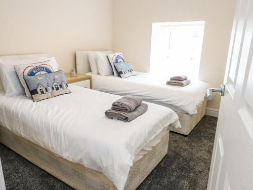 Llanerchymedd的住宿－Clydfan Cottage，客房内的两张床和毛巾