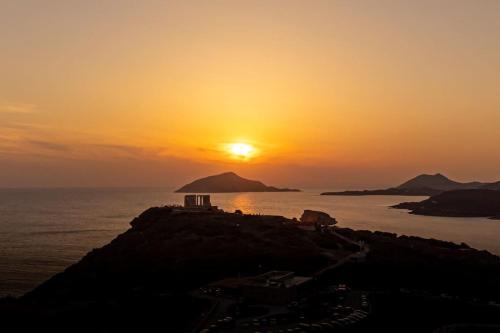 a sunset on a small island in the ocean at Lavrio stone house 5 min from the centre/port in Lávrion