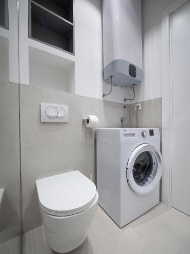 a bathroom with a toilet and a washing machine at Horizon-One bedroom apartment with pool Jane in Becici