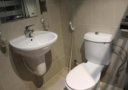 a bathroom with a white toilet and a sink at Tobal Al Hamra Hotel Apartments in Jeddah