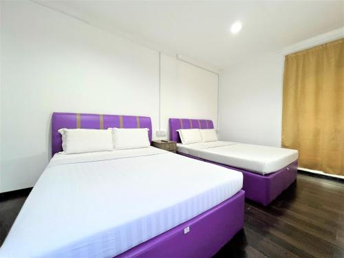 two beds in a room with purple and white at Suang Noh Homestay Kundasang in Kundasang
