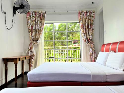 a bedroom with two beds and a window at Suang Noh Homestay Kundasang in Kundasang
