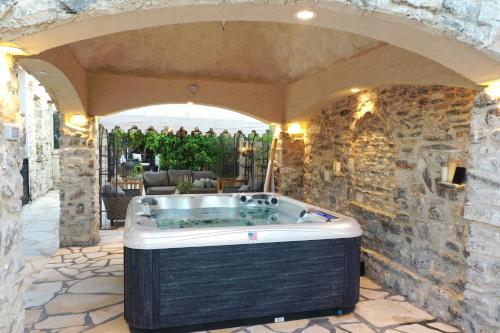 a jacuzzi tub in a stone walled yard at לאורה in Umm el Shuf