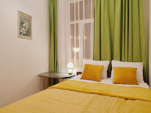リヴィウにあるАпартаменти трехкімнатні в самому центрі для 6-хのベッドルーム1室(緑のカーテンと窓付きのベッド1台付)