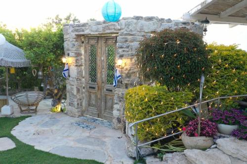 a stone wall with a wooden door in a yard at לאורה in Umm el Shuf