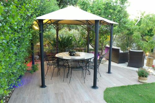 a table and chairs under an umbrella on a patio at לאורה in Umm el Shuf