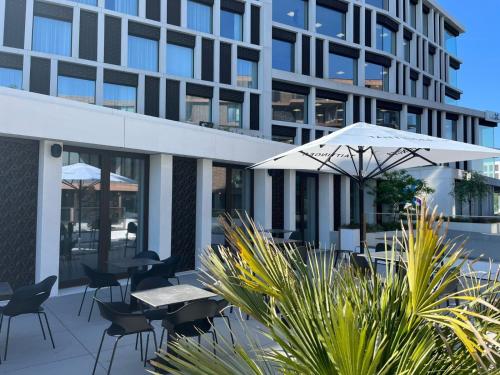 a patio with tables and chairs and a building at Radisson Blu Hotel, Bruges in Bruges