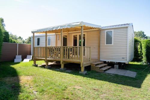 eine Holzhütte mit einer Veranda und einer Terrasse in der Unterkunft Chalets Eureka & Bloemenduin Koksijde in Koksijde