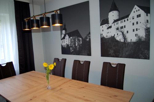 Ferienwohnung zur alten Zeche في يوهانغيورغنشتات: طاولة غرفة الطعام مع إناء من الزهور عليها