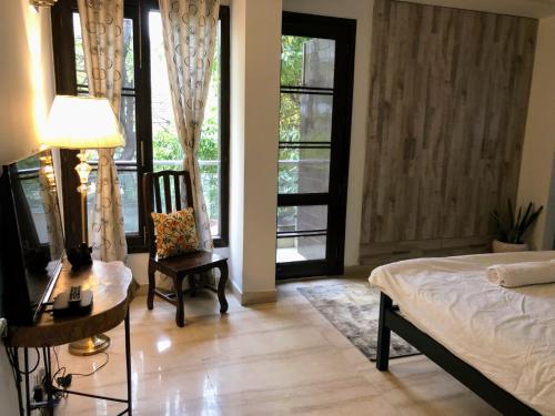 a bedroom with a bed and a desk and a chair at Avatar Living @Safdarjung Enclave in New Delhi