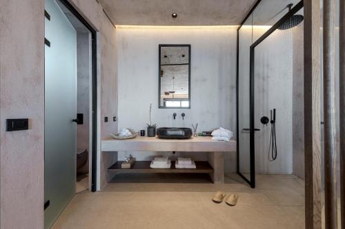 a bathroom with a sink and a mirror at North Santorini - A Luxury Spa Hotel in Pirgos