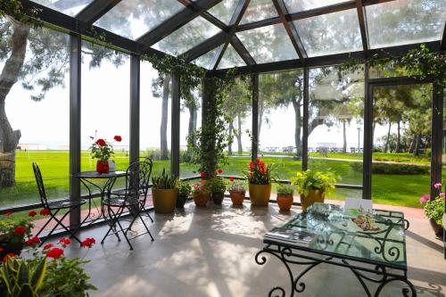 a conservatory with a table and potted plants at TUI Magic Life Rixos Beldibi - Adult Only in Beldibi