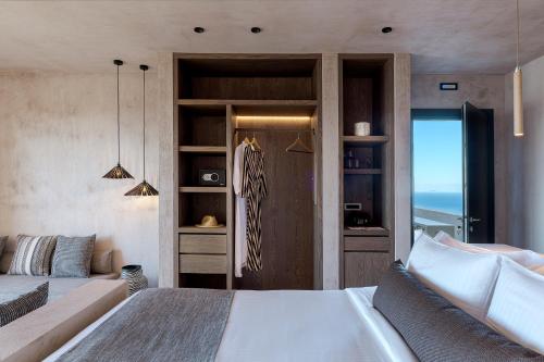 a bedroom with a bed and a view of the ocean at North Santorini - A Luxury Spa Hotel in Pirgos