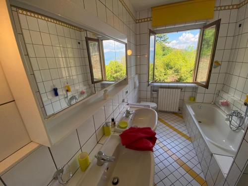 a bathroom with two sinks and a tub and a mirror at Diana Villa in Oggebbio