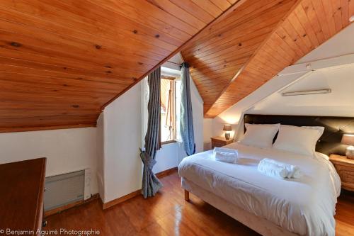 a bedroom with a large bed and wooden ceilings at Villa Lamartine in Aix-les-Bains