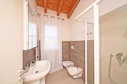 a bathroom with a sink and a toilet and a shower at Corte Fasanella 78 in Toscolano Maderno