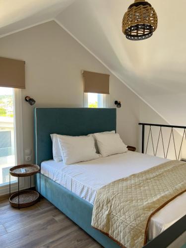 a bedroom with a bed with a blue headboard at Sithon Diamond Suites in Nikiti