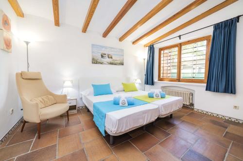 sypialnia z łóżkiem i krzesłem w obiekcie Villa Plomer Serra w Playa de Muro