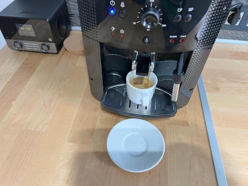 a coffee machine with a cup of coffee at St Emmerich Residence in Győr