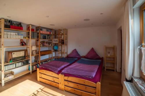 a bedroom with a wooden bed with purple sheets at Ferienwohnung Am Waldrand in Bad Driburg