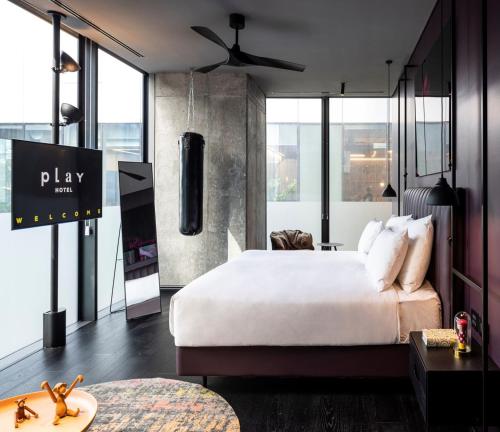 a hotel room with a large bed and large windows at Play Midtown Hotel Tel Aviv in Tel Aviv