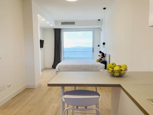 a bedroom with a bed and a table with a bowl of fruit at Boutique Lungomare in Porto Torres