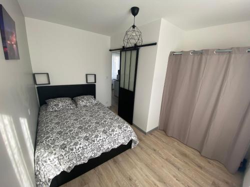 - une chambre avec un lit et une lampe pendant dans l'établissement La merveille de Rochebonne 1, à Saint-Malo