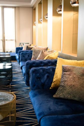 a row of blue couches sitting in a room at Primoretz Grand Hotel & Spa in Burgas City