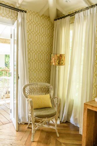 a wicker chair in a room with a window at TW Guaimbê Exclusive Suítes in Ilhabela