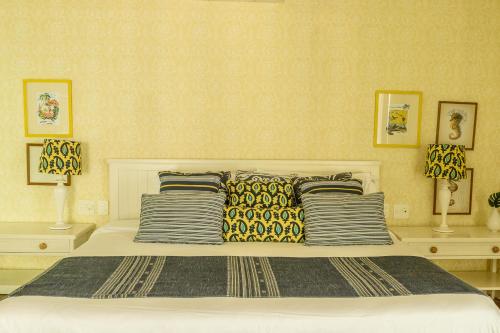 a bedroom with a large bed with three pillows at TW Guaimbê Exclusive Suítes in Ilhabela