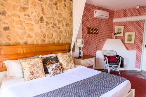 a bedroom with a bed and a table and a chair at TW Guaimbê Exclusive Suítes in Ilhabela