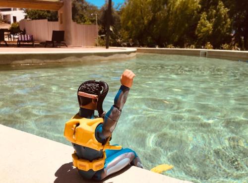a person in a life vest sitting next to a swimming pool at casa paz tavira in Tavira