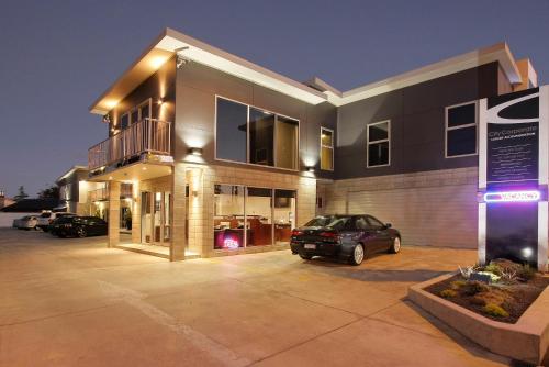 a car parked in a parking lot in front of a building at City Corporate Motor Inn in Palmerston North