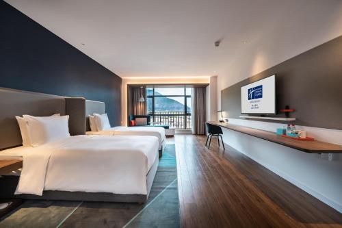 普拉的住宿－林芝华发智选假日酒店，酒店客房设有两张床和一台平面电视。