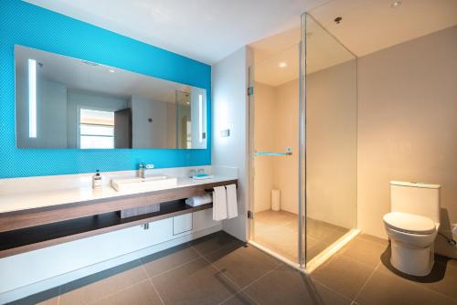 uma casa de banho com um lavatório e uma cabina de duche em vidro. em Holiday Inn Express Linzhi Airport, an IHG Hotel em Nyingchi