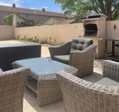 a patio with wicker furniture and a table and chairs at Coucher de soleil en Camargue in Salin-de-Giraud