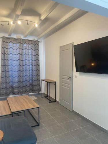 a room with a large flat screen tv on a wall at Coucher de soleil en Camargue in Salin-de-Giraud