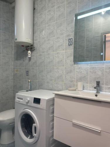 a bathroom with a washing machine and a sink at Coucher de soleil en Camargue in Salin-de-Giraud