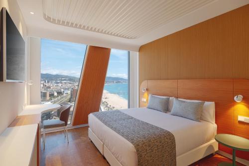 Habitación de hotel con cama y ventana grande en Hotel Marina Badalona en Badalona