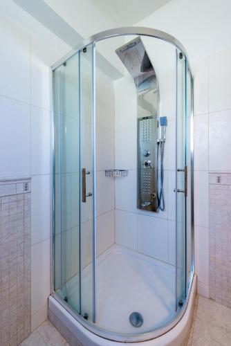 a shower with a glass enclosure in a bathroom at Dias Luxury Villa in Koskinou