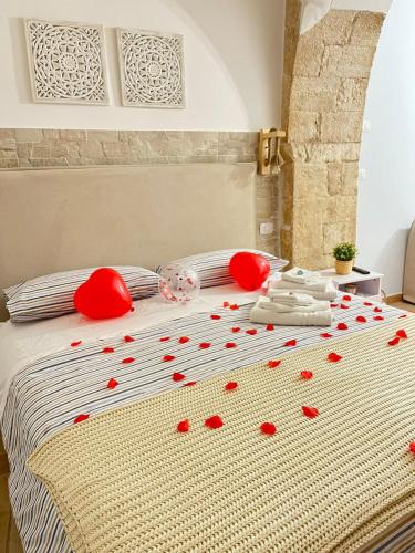 a bed with red rose petals on it at Casa vacanze LaCorte ByFrancy in Bari