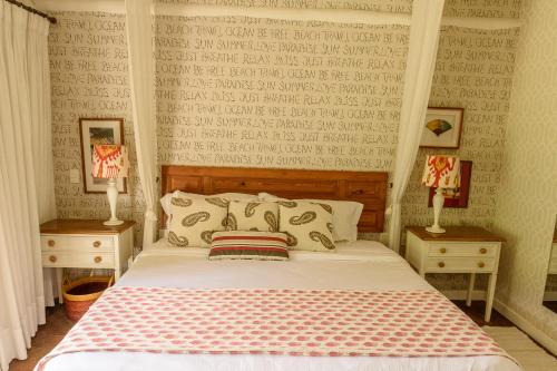a bedroom with a bed with two night stands and two lamps at TW Guaimbê Exclusive Suítes in Ilhabela