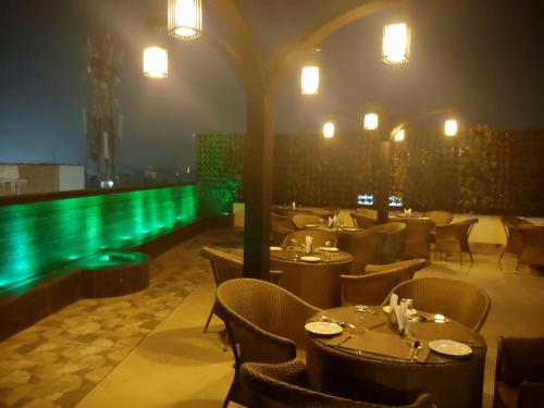 a restaurant with tables and chairs and a swimming pool at HOTEL SHIVOY GRAND in Varanasi