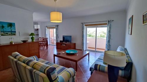 a living room with a couch and a table at T-3 1Arcos - Casas & Papeis in Armação de Pêra