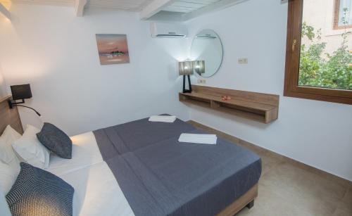 a bedroom with a bed in a room with a mirror at Ida Village I & II in Hersonissos