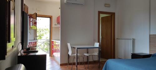 a bedroom with a table and chairs and a bed at Villa Smeraldo Roma in Infernetto