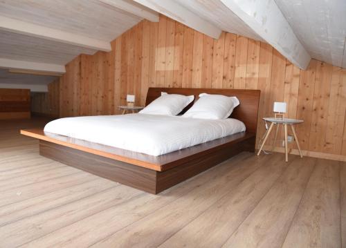 - une chambre dotée d'un lit avec des murs en bois et du parquet dans l'établissement Villa Fabregas, à La Seyne-sur-Mer