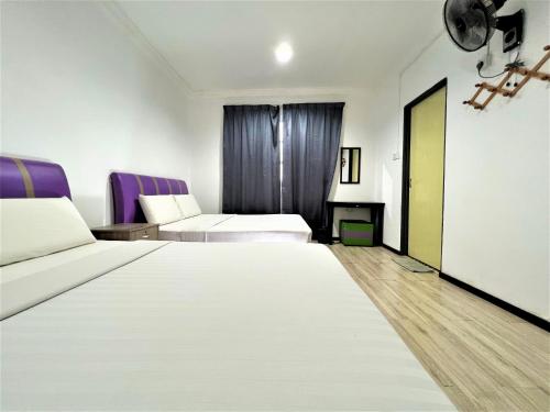 a hotel room with two beds and purple chairs at Suang Noh Homestay Kundasang in Kundasang
