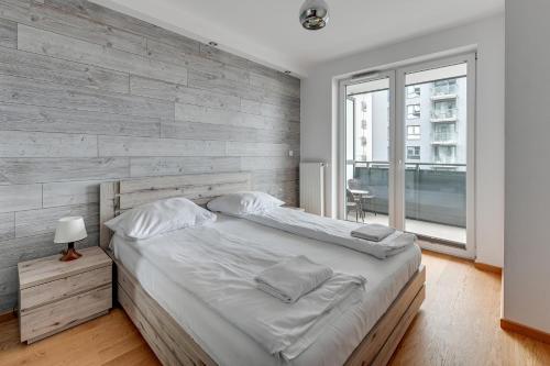 グダニスクにあるGrand Apartments - Luxury apartment on the 11th floor with a view of the Old Townの大きなベッドと窓のある寝室