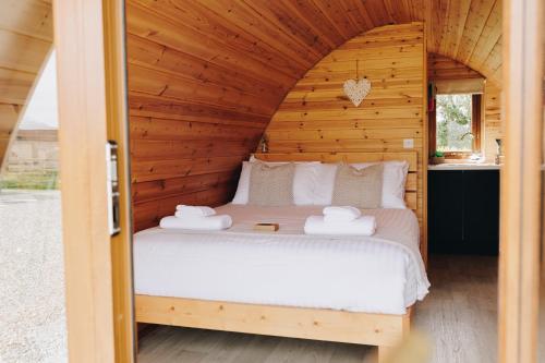 a bedroom with a bed in a wooden cabin at North Coast 9 Glamping in Cape Castle